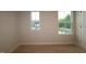 A bright bedroom with carpet, two windows looking out to the neighborhood, and neutral colored walls create a relaxing ambiance at 920 Montague Ave, Durham, NC 27703