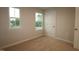 A cozy bedroom featuring plush carpeting, natural light from two windows, and a closet for storage at 920 Montague Ave, Durham, NC 27703