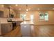 A well-lit kitchen featuring gray cabinets, stainless steel appliances, an island and wood flooring extends to dining area at 920 Montague Ave, Durham, NC 27703