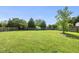 A spacious backyard with lush green grass, mature trees, and a wooden fence at 9220 Cornwell Dr, Wake Forest, NC 27587