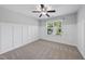 A neutral bedroom featuring board and batten accent wall and a ceiling fan at 9220 Cornwell Dr, Wake Forest, NC 27587