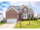 Charming two-story brick home featuring a well-manicured lawn and a two-car garage at 9220 Cornwell Dr, Wake Forest, NC 27587