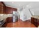 Modern kitchen featuring a stainless steel refrigerator, granite countertops, and wooden cabinetry at 9220 Cornwell Dr, Wake Forest, NC 27587