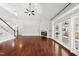 Spacious living room with hardwood floors, fireplace, ceiling fan, and abundant natural light from French doors at 9220 Cornwell Dr, Wake Forest, NC 27587