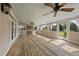 A screened porch featuring a brick fireplace, ceiling fans, and a wood paneled floor at 9220 Cornwell Dr, Wake Forest, NC 27587