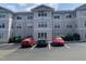 Condo complex featuring light pink siding with white trim, multiple windows, and designated parking spaces at 929 Morreene Rd # C-14, Durham, NC 27705