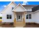 Inviting home entrance featuring a light-colored exterior, wood porch, and glass pane front door at 9427 Turkey Way, Middlesex, NC 27557