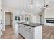 Granite kitchen island with white cabinetry, and an adjacent fireplace with white brick surround at 9427 Turkey Way, Middlesex, NC 27557