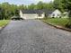 Long gravel driveway leading to a charming home with an attached two-car garage at 956 W Greensboro Chapel Hill Rd, Snow Camp, NC 27349