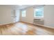 Bright bedroom with hardwood floors, two windows, and an air conditioning unit at 979 St Marys St # G6, Raleigh, NC 27605
