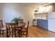 Compact kitchen adjacent to dining area, featuring hardwood floors and essential appliances for convenient living at 979 St Marys St # G6, Raleigh, NC 27605