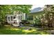 Serene backyard featuring a patio, screened porch, lush greenery, and mature trees at 1008 Old Meetinghouse Way, Raleigh, NC 27615