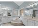 Spa-like bathroom featuring a large soaking tub, double vanities, and natural light at 1008 Old Meetinghouse Way, Raleigh, NC 27615