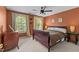 Bedroom featuring a queen bed, ceiling fan, windows, and an earthy color palette at 1008 Old Meetinghouse Way, Raleigh, NC 27615