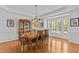 Bright dining room featuring hardwood floors, a chandelier, and a cabinet for glassware at 1008 Old Meetinghouse Way, Raleigh, NC 27615