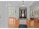 Bright and airy foyer with hardwood floors, white columns, and an elegant front door at 1008 Old Meetinghouse Way, Raleigh, NC 27615