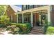 Charming front porch with brick steps, white columns, and lush landscaping at 1008 Old Meetinghouse Way, Raleigh, NC 27615
