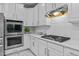 Modern kitchen with stainless steel appliances, white cabinetry, and a gas range at 1008 Old Meetinghouse Way, Raleigh, NC 27615