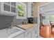 Bright kitchen detail with white cabinets, grey backsplash, and modern sink at 1008 Old Meetinghouse Way, Raleigh, NC 27615