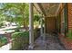 Inviting porch with stone tile flooring, white columns, and a wrought iron railing at 1008 Old Meetinghouse Way, Raleigh, NC 27615