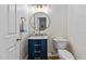 Chic powder room with a navy vanity, brass fixtures, and patterned wallpaper at 1008 Old Meetinghouse Way, Raleigh, NC 27615