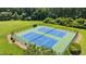 Top-down view of community tennis courts with freshly painted blue courts and lush green landscaping at 1008 Old Meetinghouse Way, Raleigh, NC 27615