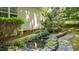 Backyard stream with rock-lined banks, lush greenery, and a gentle waterfall offering a tranquil landscape at 1008 Old Meetinghouse Way, Raleigh, NC 27615