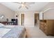 Bedroom with a ceiling fan, ensuite bath, office space, and neutral color palette at 1009 Porchside Dr, Apex, NC 27502