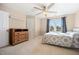 Cozy bedroom featuring a ceiling fan, dresser, and a window offering natural light at 1009 Porchside Dr, Apex, NC 27502
