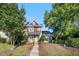 Charming two-story home with a welcoming front porch, mature trees, and well-manicured landscaping at 1009 Porchside Dr, Apex, NC 27502