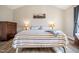 Spacious main bedroom featuring a striped quilt, wood-look floors, and vaulted ceilings at 1009 Porchside Dr, Apex, NC 27502