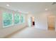 Primary bedroom with plush neutral carpet, abundant natural light, and an attached walk-in closet at 1015 Regalia Rd # 27, Durham, NC 27713