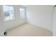 Bedroom with neutral walls, plush carpeting, and abundant natural light from two windows at 1015 Regalia Rd # 27, Durham, NC 27713