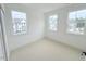 Bedroom with neutral walls, plush carpeting, and abundant natural light from three windows at 1015 Regalia Rd # 27, Durham, NC 27713