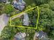 Aerial view of a property surrounded by lush trees, highlighting the property lines and landscaped yard at 102 Alidade Ct, Cary, NC 27513