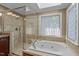 Bathroom showcasing a luxurious soaking tub and a walk-in glass shower with natural light from the window at 102 Alidade Ct, Cary, NC 27513