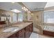 Elegant bathroom features dual sinks, granite countertops, a skylight, and glass enclosed shower and bathtub at 102 Alidade Ct, Cary, NC 27513
