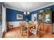 Charming dining room with rich blue walls, elegant chandelier, and hardwood floors, perfect for entertaining at 102 Alidade Ct, Cary, NC 27513