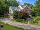 Back exterior view with garage, lush landscaping, and stone driveway at 102 Alidade Ct, Cary, NC 27513