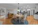Bright kitchen featuring a wooden table set on a braided rug, with stainless steel appliances and white cabinetry at 102 Alidade Ct, Cary, NC 27513