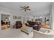 Spacious living room showcases leather furniture, a ceiling fan, and an open layout connecting to the kitchen at 102 Alidade Ct, Cary, NC 27513