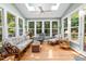 Bright sunroom with multiple windows, skylights, and casual seating with hardwood flooring at 102 Alidade Ct, Cary, NC 27513