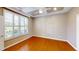 Bedroom with hardwood floors, tray ceiling with fan, and window with shutters at 112 Salmon River Dr, Durham, NC 27705