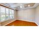 Bright bedroom with tray ceiling, ceiling fan, hardwood floors, and large window with white shutters at 112 Salmon River Dr, Durham, NC 27705