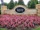 Thompson Ridge community sign with stone accents, framed by vibrant pink flowers for an inviting entrance at 112 Salmon River Dr, Durham, NC 27705