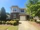 Inviting two-story townhome with stone accents, attached single car garage, and well maintained landscaping at 112 Salmon River Dr, Durham, NC 27705