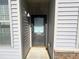 Charming front door with a window panel, neutral siding, and a stone accent, creating an inviting entryway at 112 Salmon River Dr, Durham, NC 27705