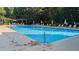 Community pool with lounge chairs, sun umbrellas, and lush greenery in the background at 112 Salmon River Dr, Durham, NC 27705