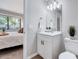 Bathroom showcases a white vanity, modern lighting and a glimpse into a bedroom through an open door at 1221 Teakwood Pl, Raleigh, NC 27606
