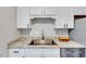 Close up view of stainless steel appliances, white cabinets, and granite countertops in updated kitchen at 1221 Teakwood Pl, Raleigh, NC 27606